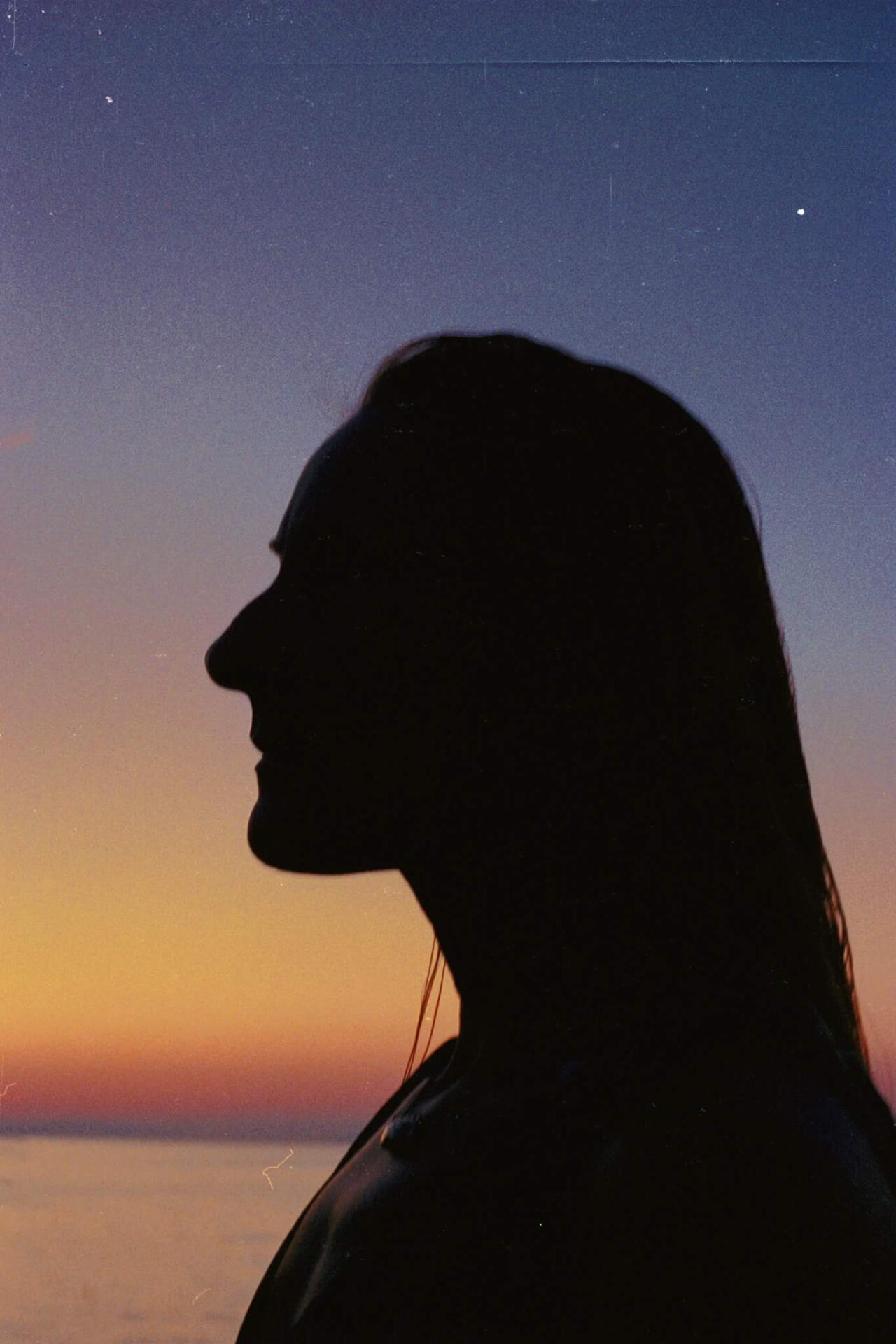 Icon is a image of a human profile against a sunset